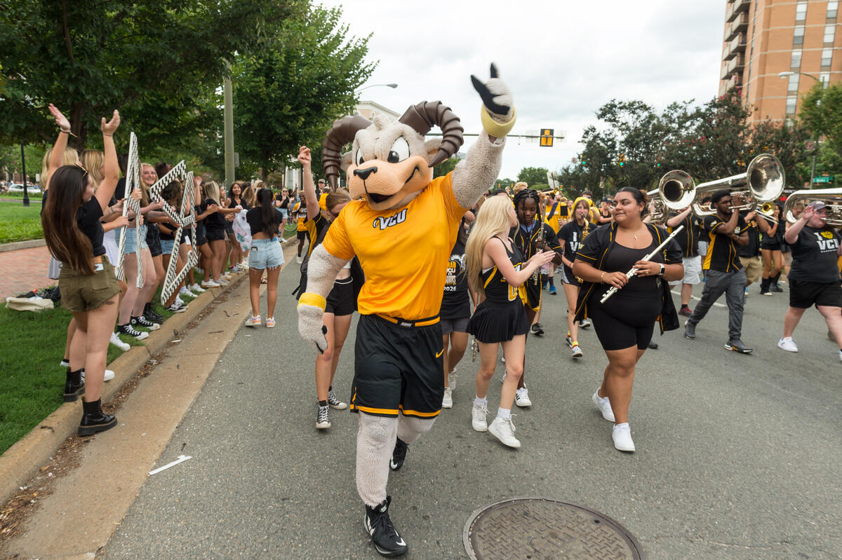 Rodney the Ram walking in front of the pep band 