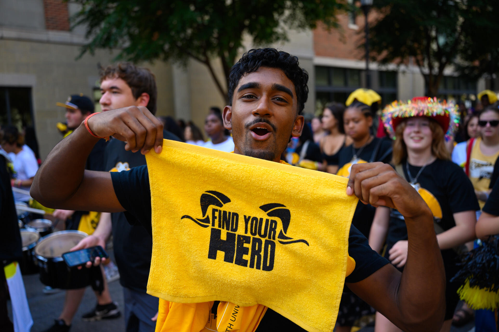 A man holds up a gold towel.
