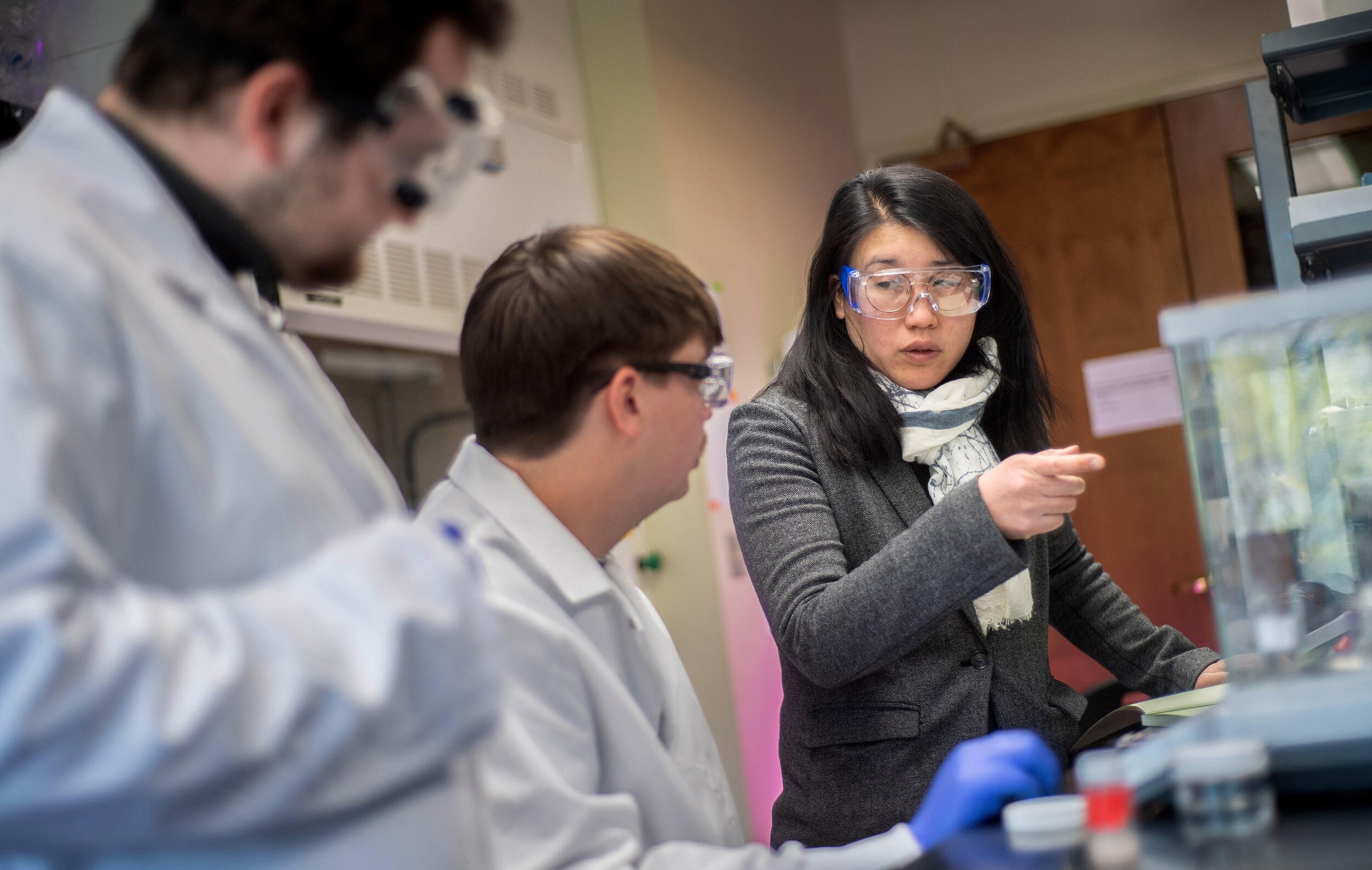 A photo of three people in a lab. 