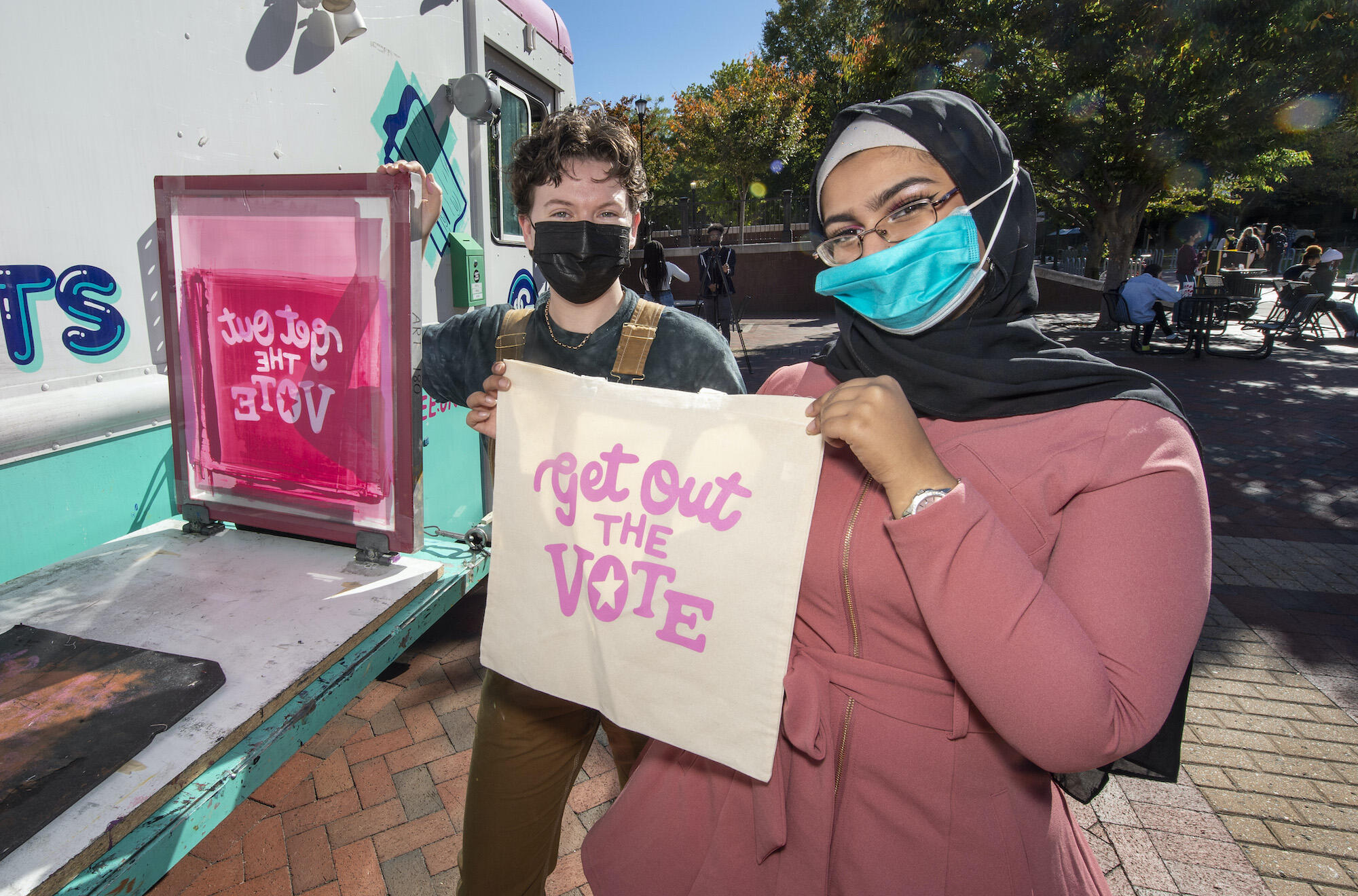 Students hold up screen-printed tote bags at a VCU Votes event on Oct. 27. 