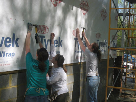 Students Laura Baker, Adriennne Kotula and Rebecca Ribe support Habitat for Humanity’s mission of providing affordable housing. Photo by Mike Porter, University Communications and Public Relations. 