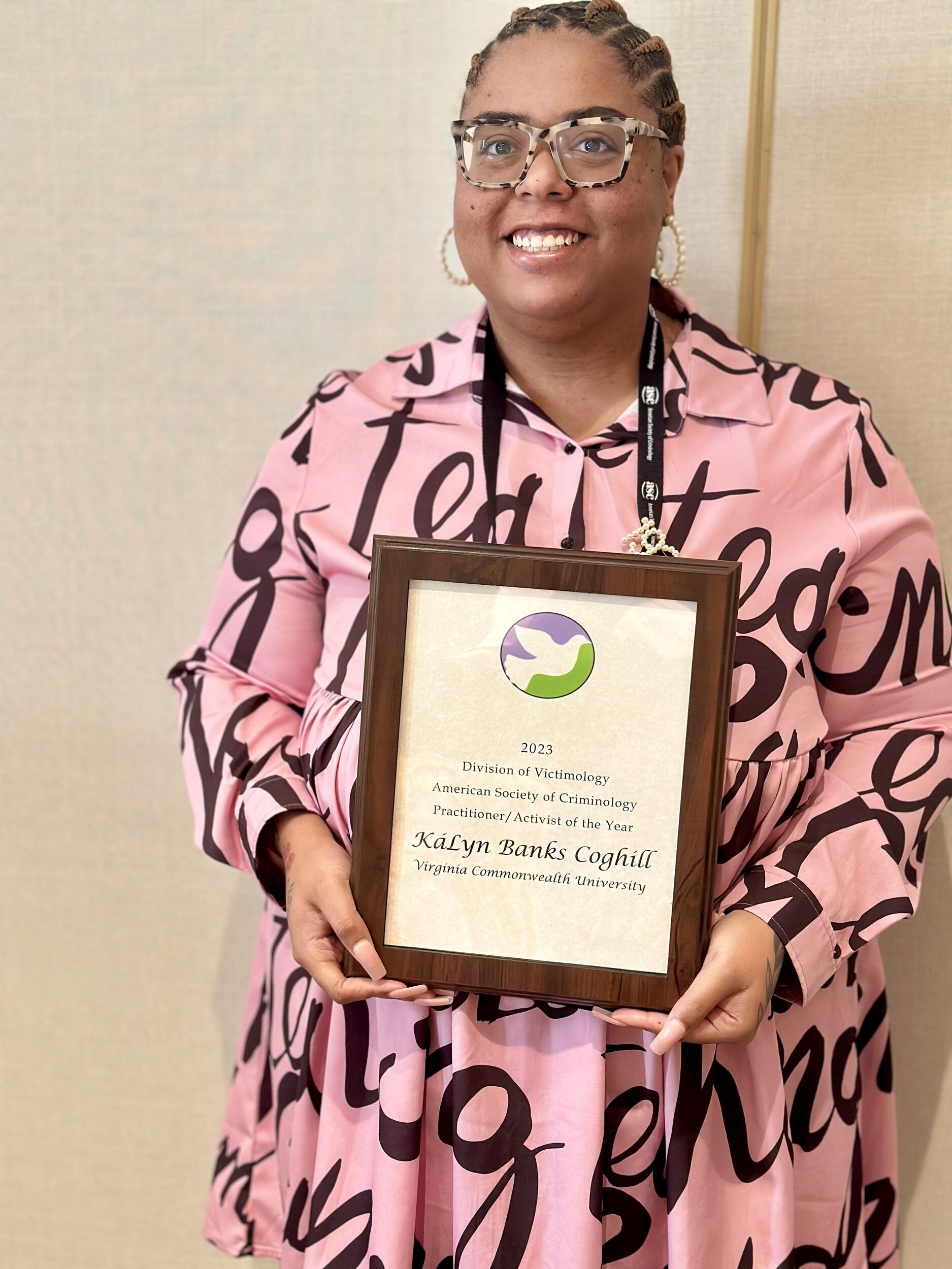 A photo of a woman holding an award certificate 