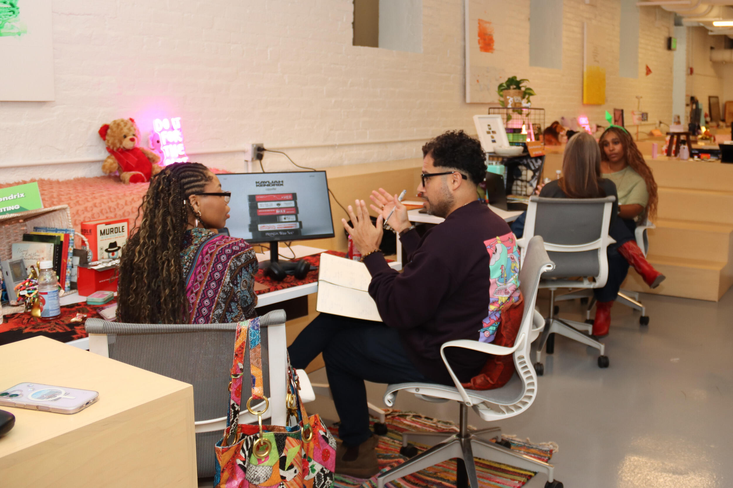 A woman and a man sit in chairs talking.