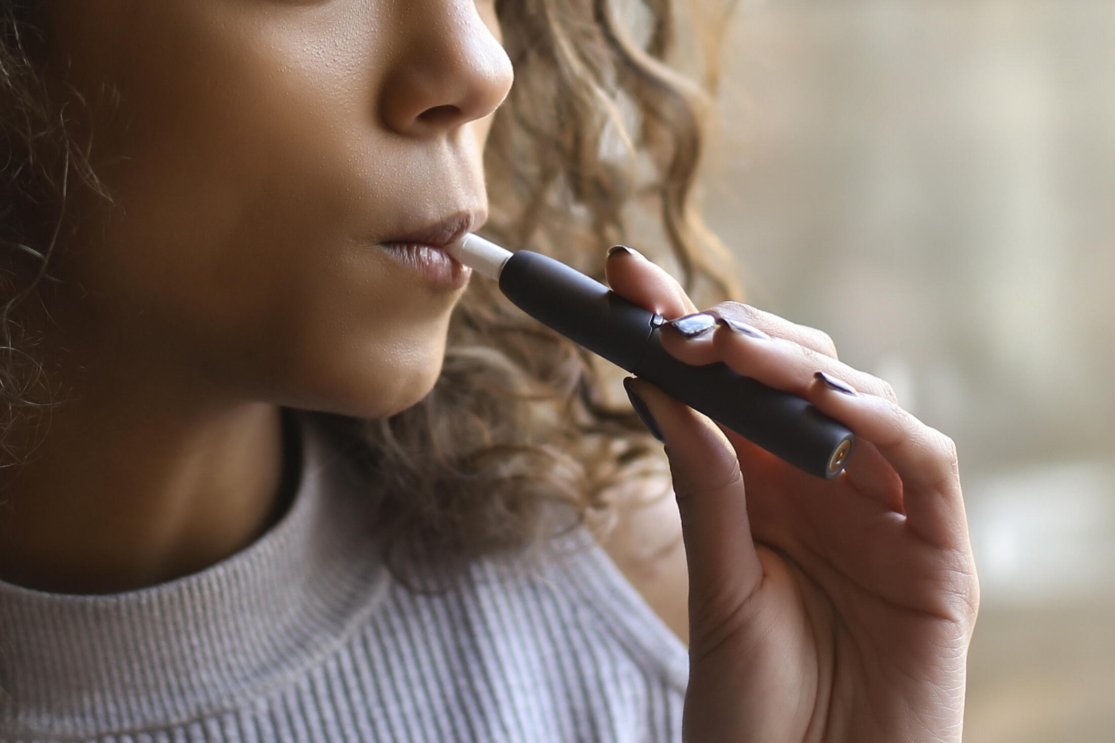 young Black woman smoking an e-cigarette