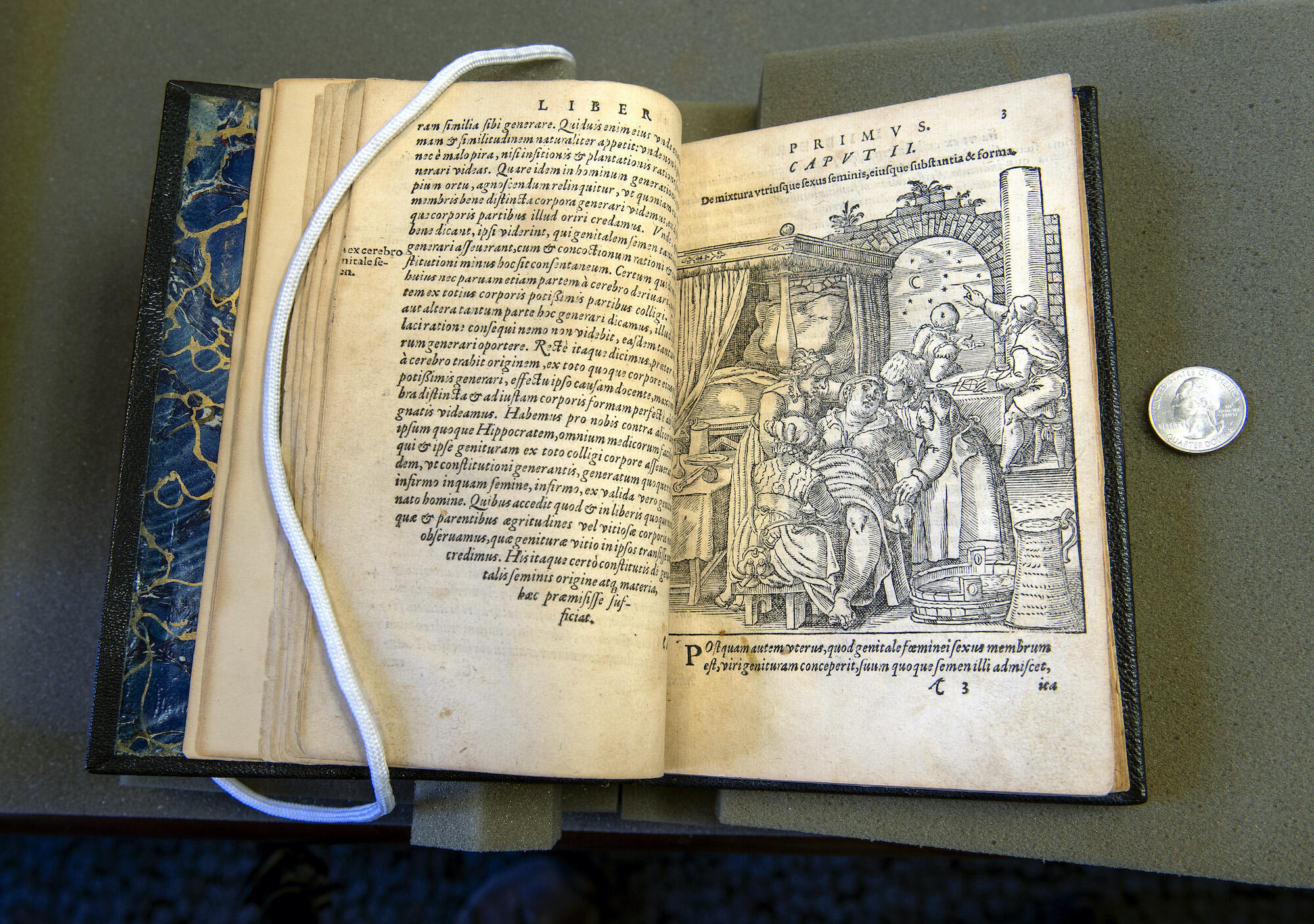 16th century medical illustration book, with image showing a birthing stool, a midwife's instruments hanging from her belt, and the scissors and twine on the table for cutting and tying the umbilical cord. The the background, two men are charting star positions to create a horoscope for the infant. 