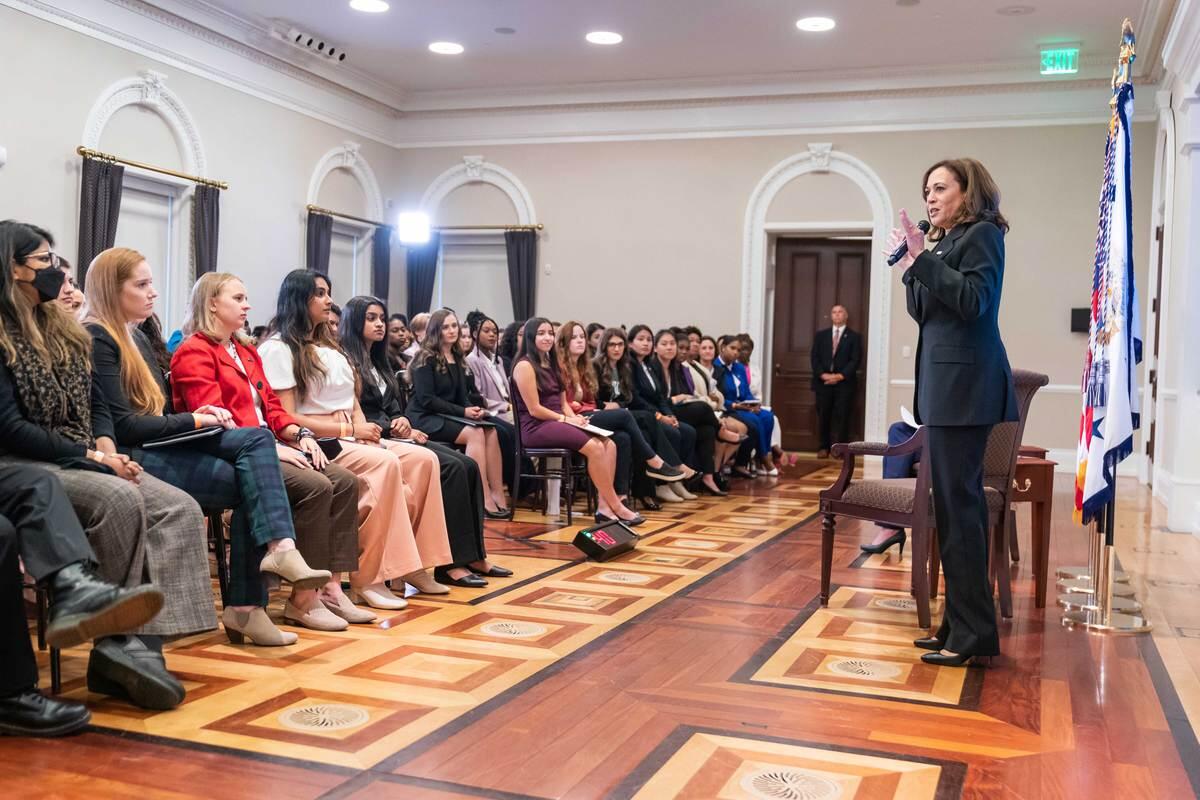 Vice President Kamala Harris speaks with a microphone to a crowd of seated college students.