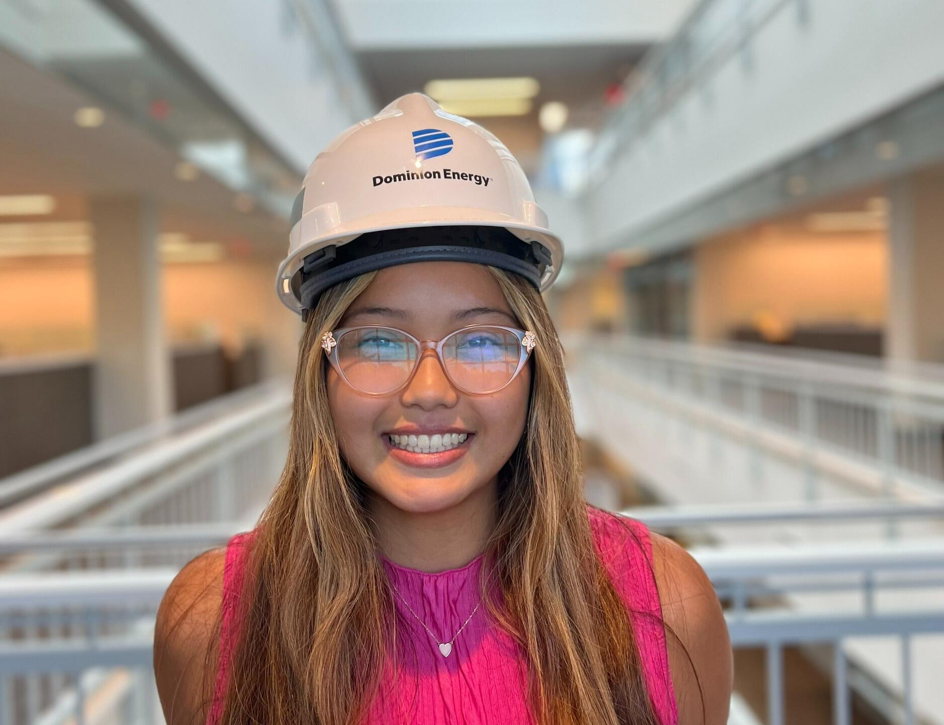 A photo of a woman wearing a hard hat and safety glasses. 