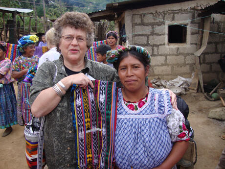 After a day of sharing games and hot cocoa and learning to weave and make corn tortillas in the remote village of Espunpuja, Janett Forte, MSW, assistant professor of psychiatry, (left,) purchases a blanket from a Mayan woman.  Photo provided by Janett Forte.  