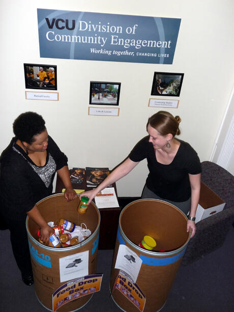 A peanut butter shortage at the Central Virginia Foodbank brought an overwhelming response from the VCU community.  VCU and the VCU Health System conducted peanut butter collections during March. In this photo, VCU AmeriCorps Co-Directors Erin Brown (left) and Elizabeth Dodson add containers of peanut butter to the collection barrels at the Division of Community Engagement office. In all, more than 2,100 pounds of peanut butter were collected. Photo by Mike Porter, VCU Communications and Public Relations. 