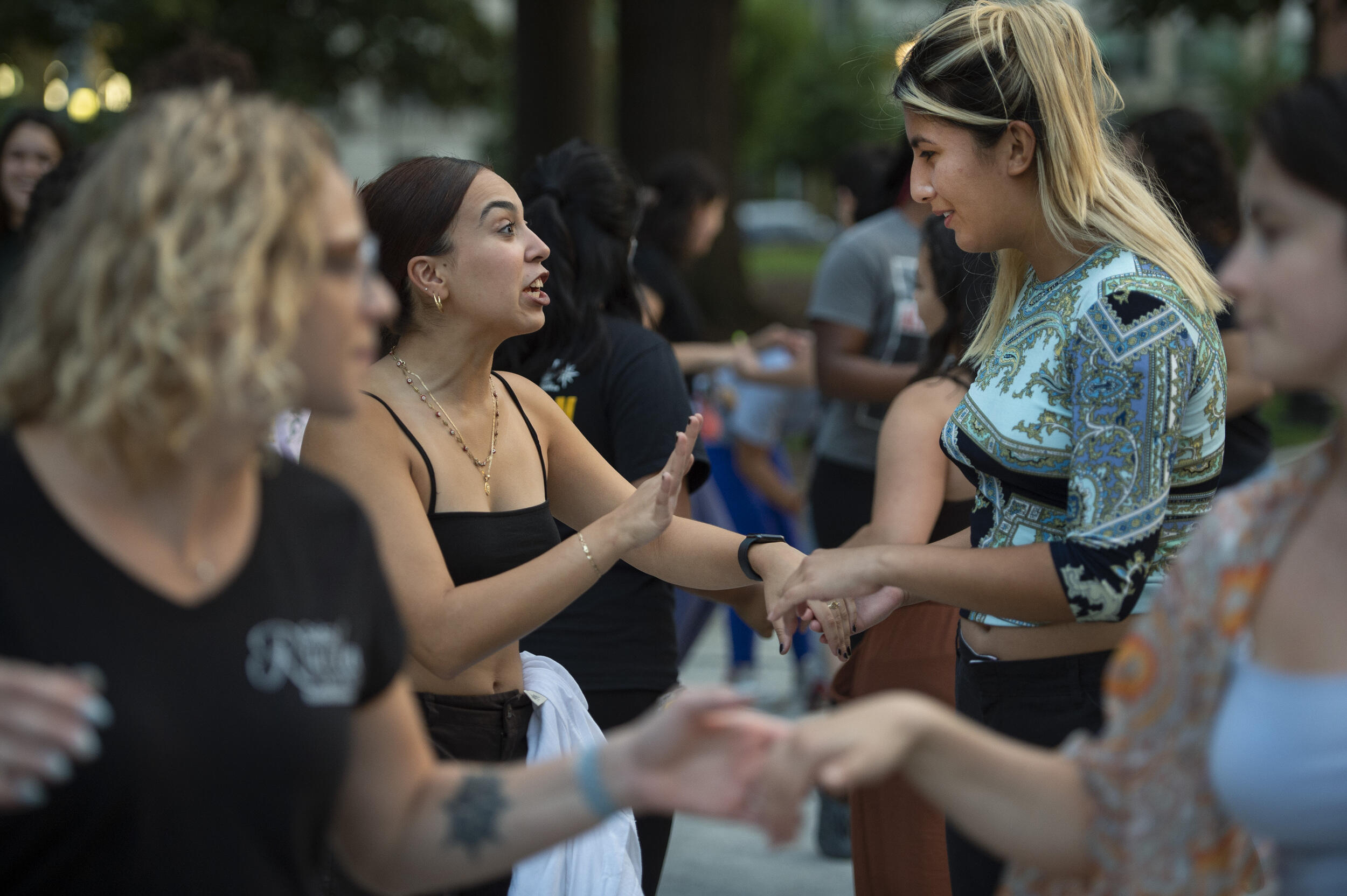 Four women dancing with each other in Monroe Park 