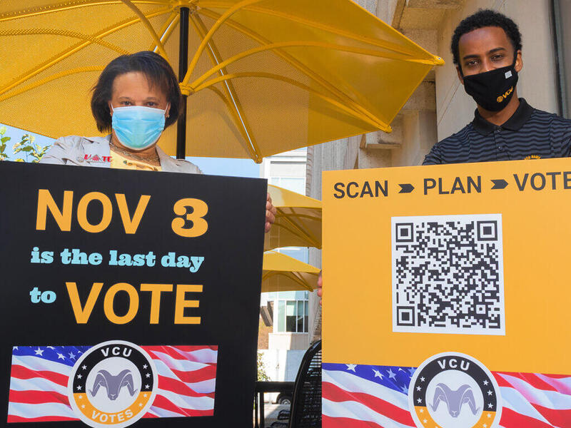 Jacqueline Smith-Mason, Ph.D. and Matt Tessema each holding V C U Votes signs encouraging people to vote.