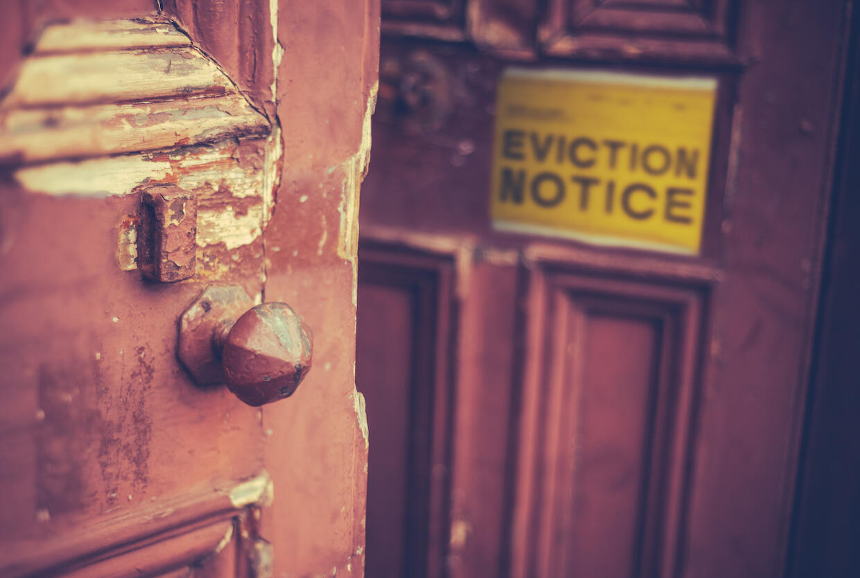 A front door to a home with a sign saying \"Eviction Notice.\"