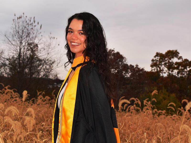 A photo of a woman wearing a graduation cap and gown