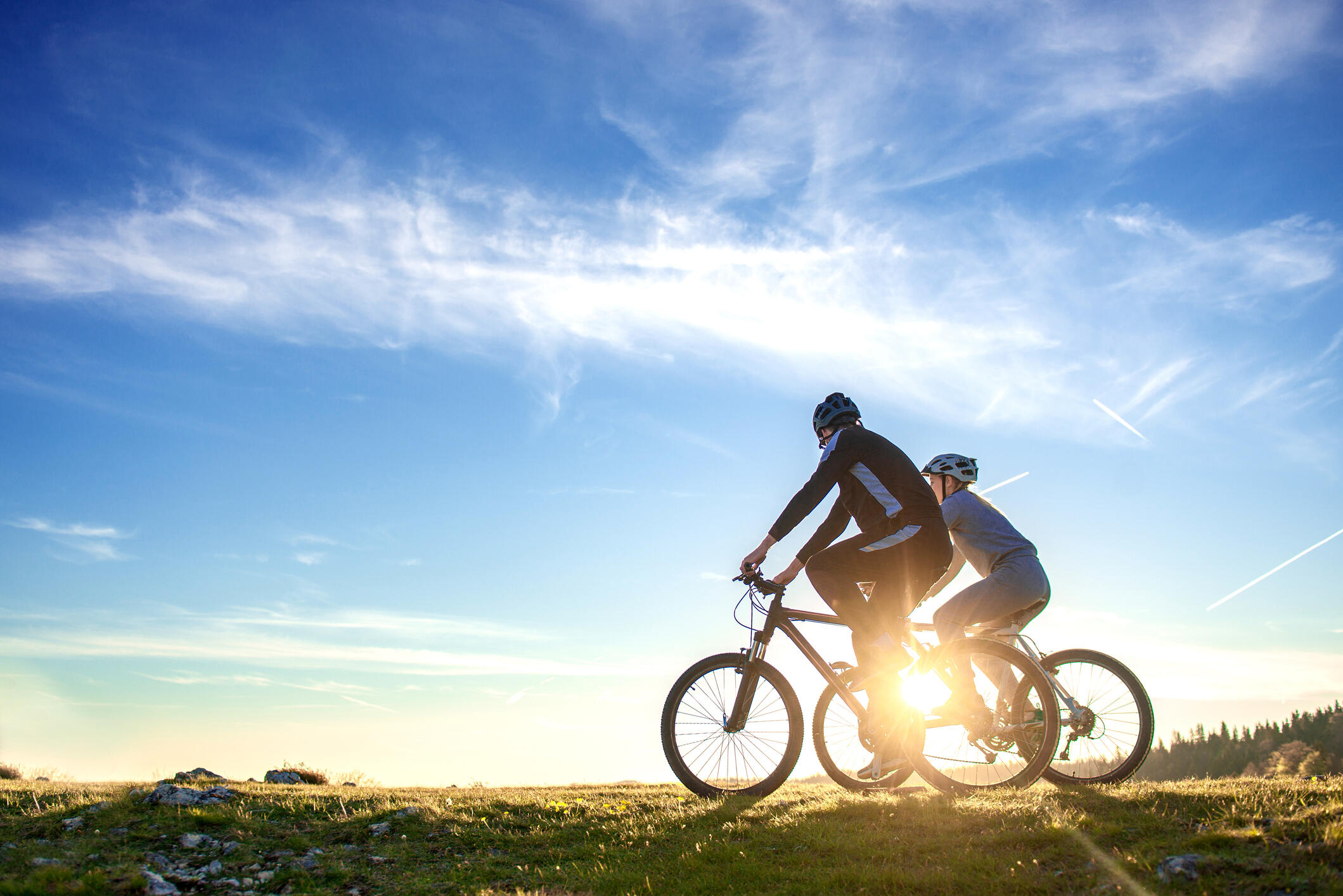 A photo of a man and a woman on two bikes next to each other 