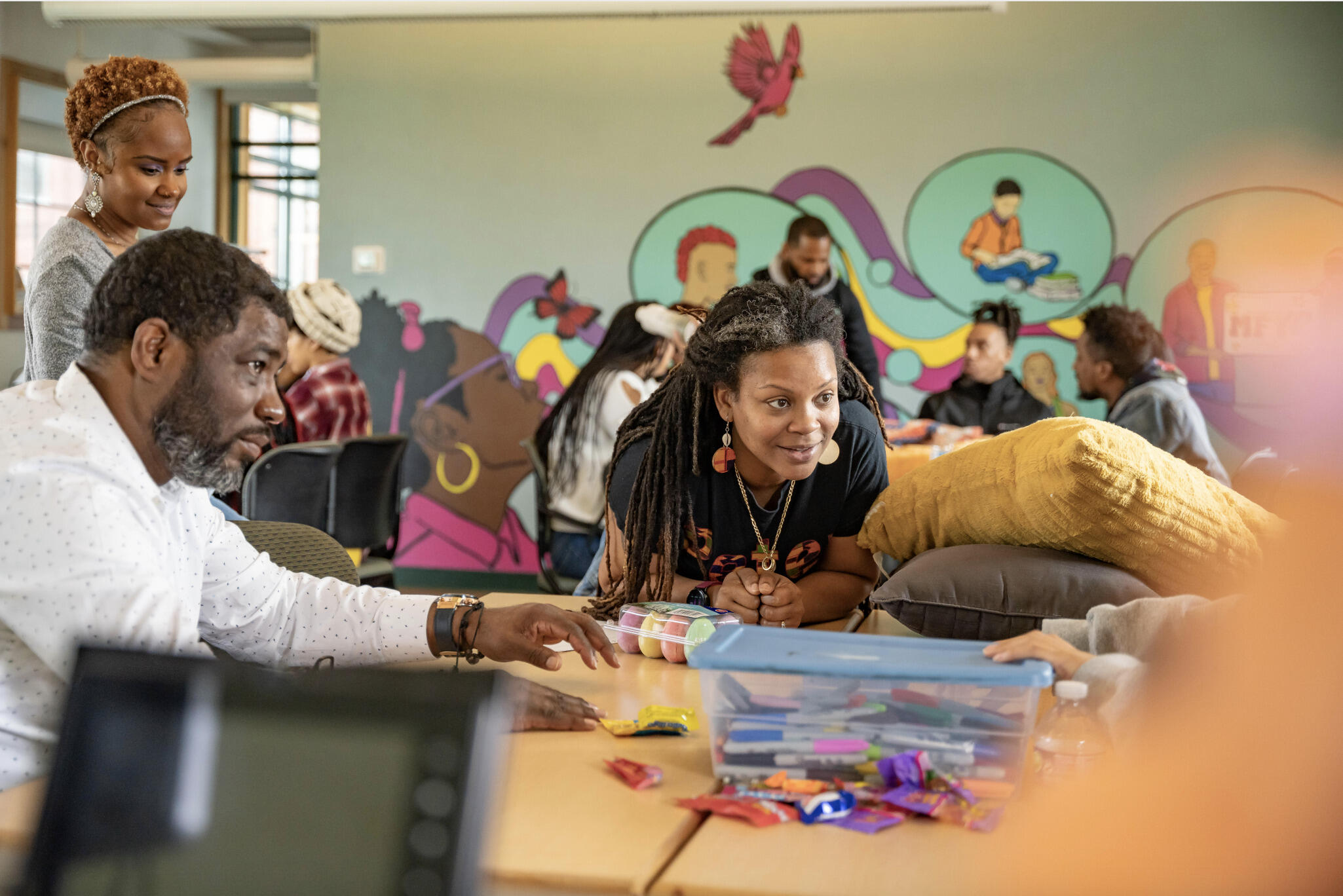 A photo of two adults loking over at a child. 