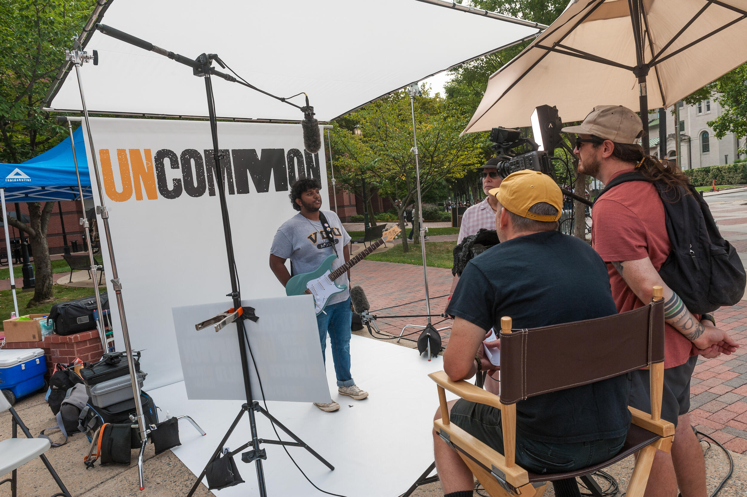 A person standing in front of a backdrop that says \"uncommon\"