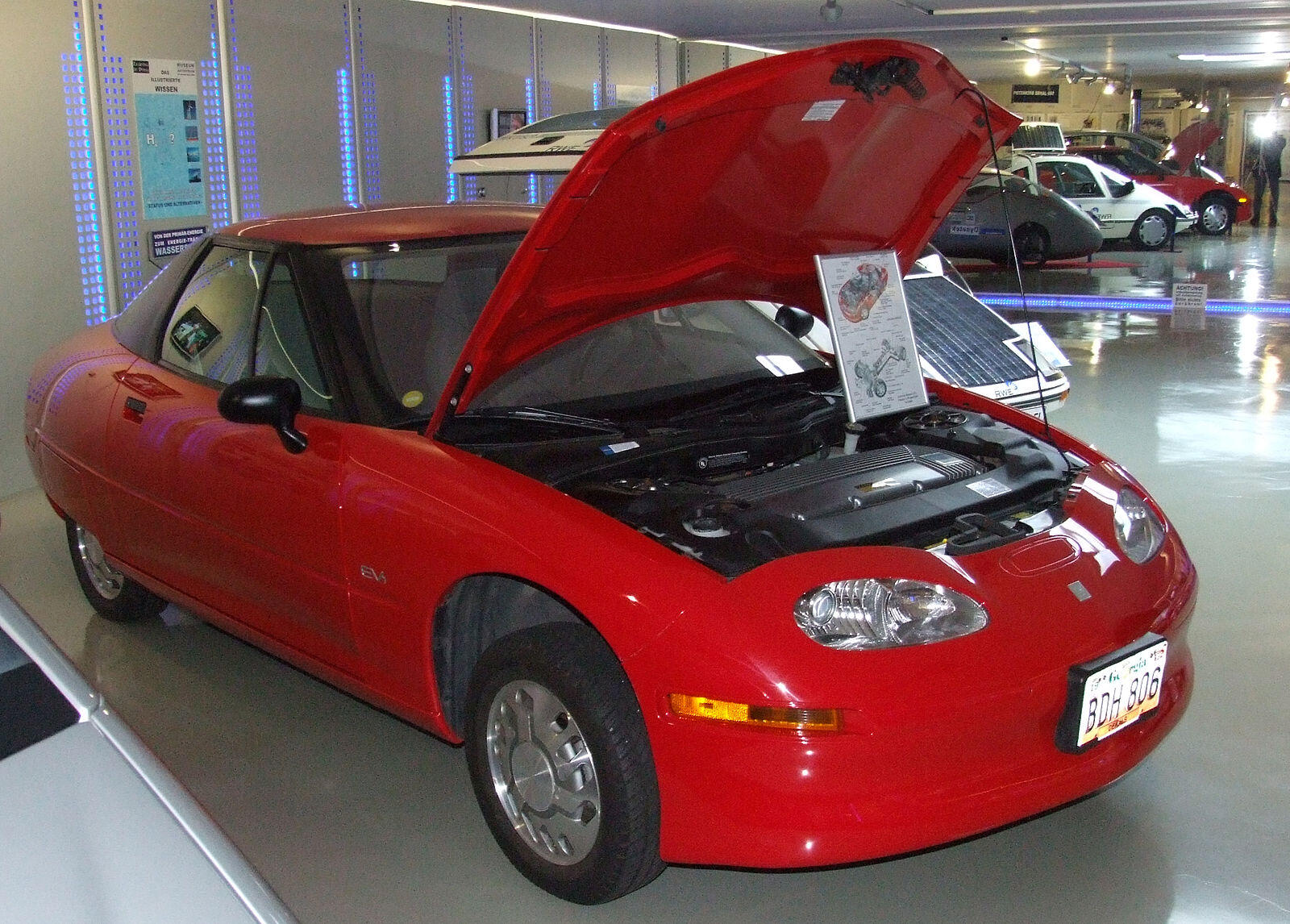 The EV1, the first modern electric car, displayed in a car museum showroom.