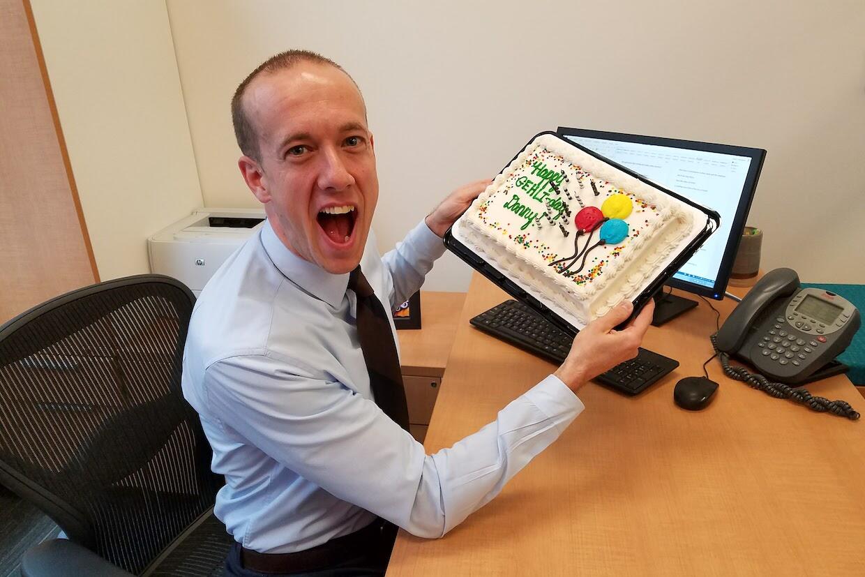 Danny Woodward holding a cake.