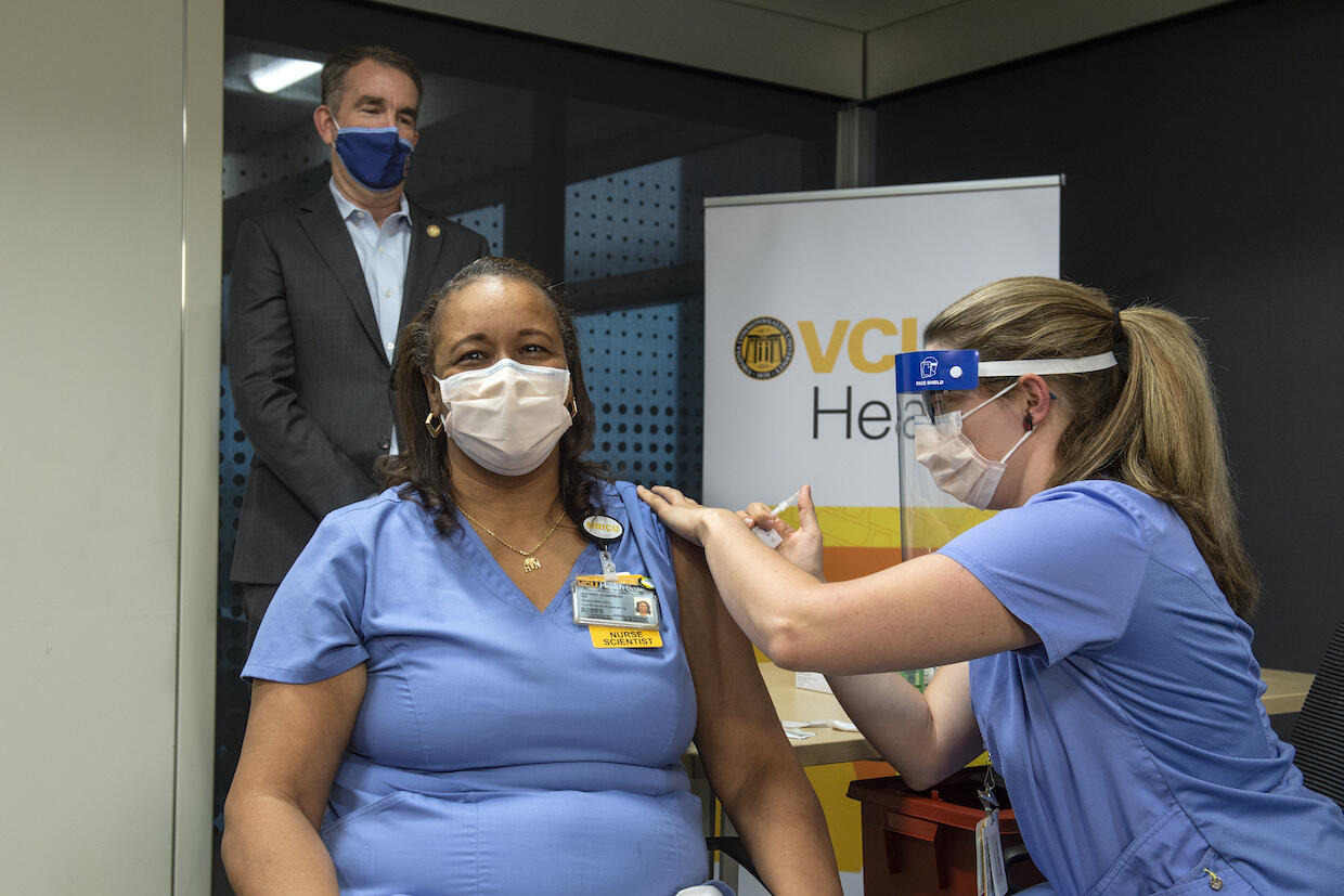 Audrey Roberson receives a vaccination shot with Virginia Governor Ralph Northam looking on.