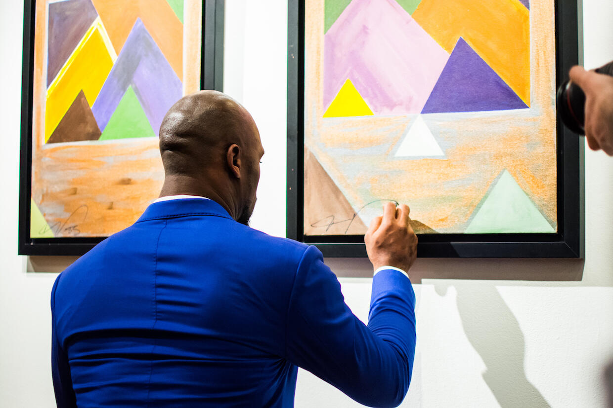 NFL player Vernon Davis signs his artwork at 1708 Gallery. (Photo courtesy of The Abstract Athlete)