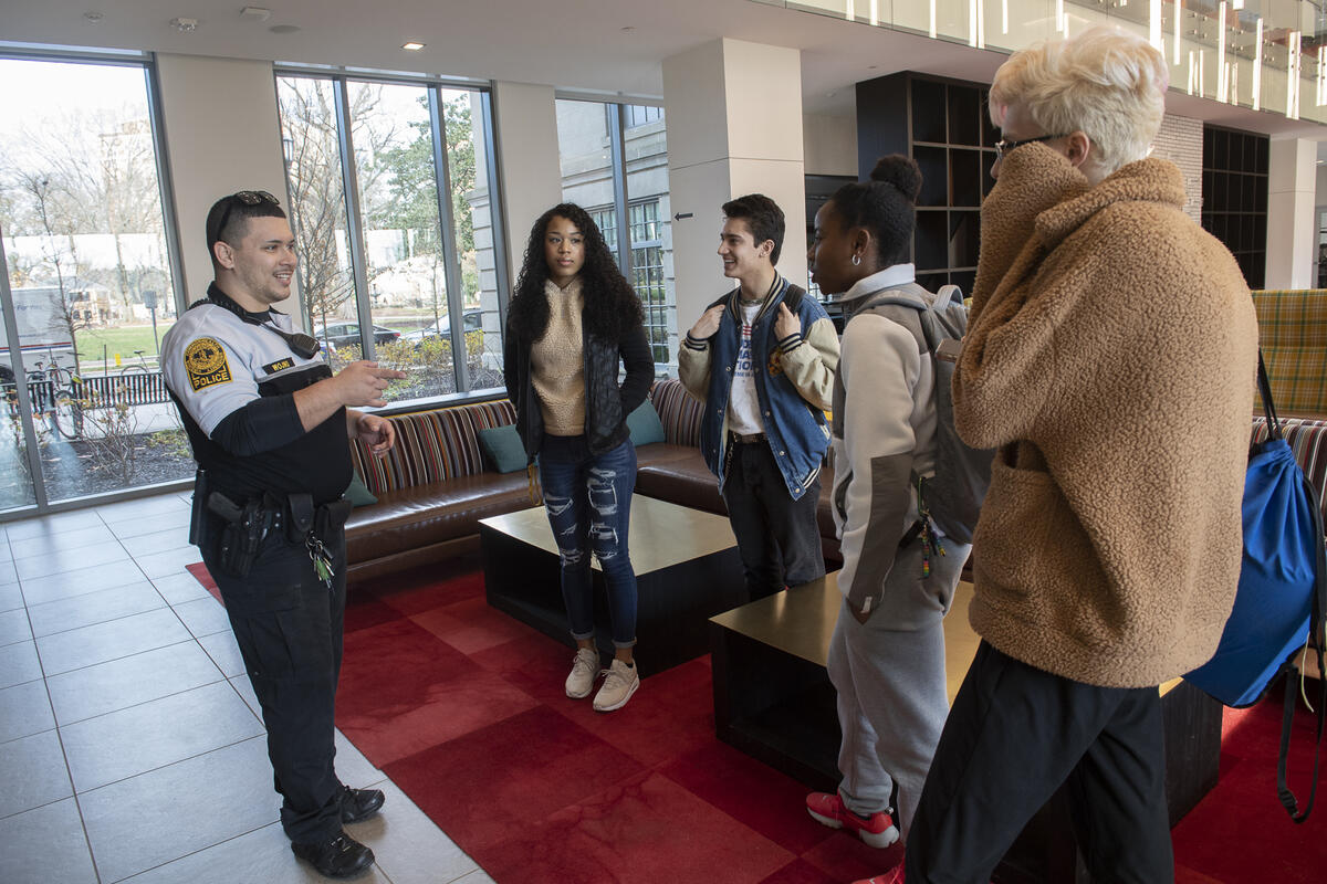 A VCU Police Officer speaks with four students.