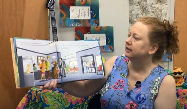 Woman reading book in front of camera. 