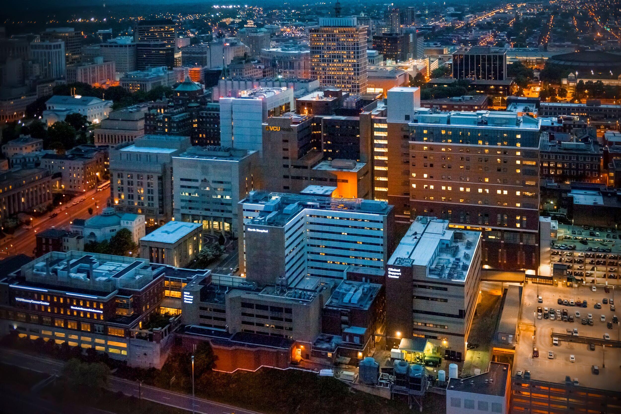An areal photo of MCV campus lit up at night. 