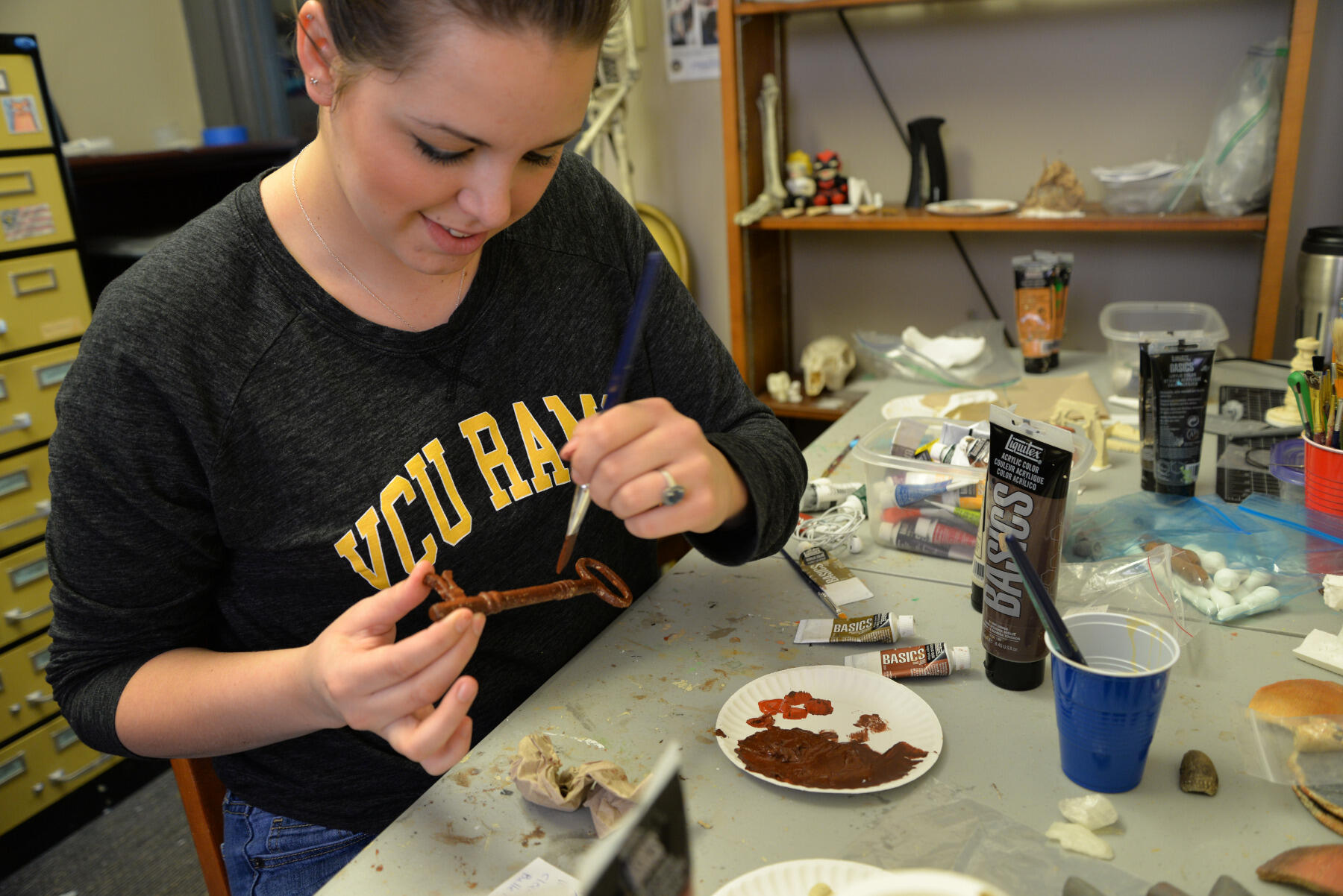 Jesse Fortune, a senior history major, paints a 3-D-printed replica of the key to Libby Prison.
