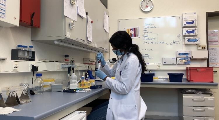 A woman in a lab coat holding a beaker 