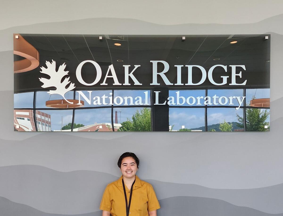 A photo of a person standing in front of a sign that says \"Oak Ridge\"