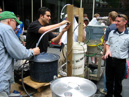 Mechanical engineering professor Daniel P. Cook (right) watches his students battle to raise and lower the temperature of a bucket of water using heat exchangers they designed themselves.

Photo by Mike Frontiero, University News Services