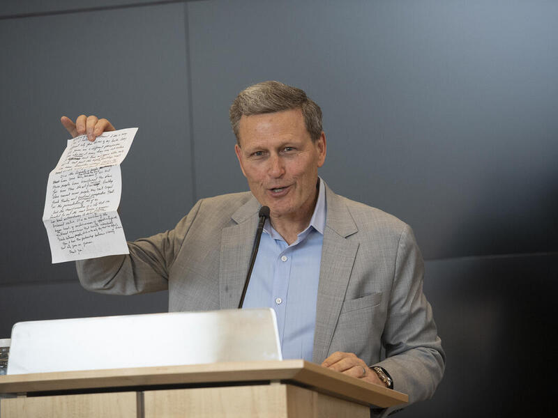 David Baldacci shows his handwritten remarks to attendees at the VCU Libraries Rising Scholars Program book and author luncheon. Baldacci shared that he writes his best-selling novels in longhand. (Tom Kojcsich, Enterprise Marketing and Communications)
