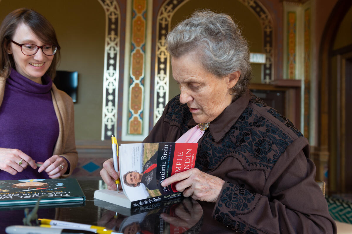 Temple Grandin signing a book for an attendee.