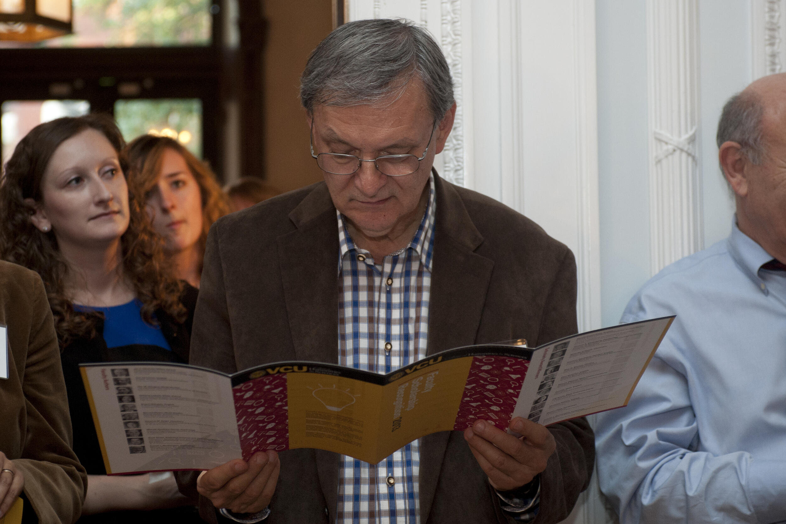 A photo of a man reading a pamphlet 