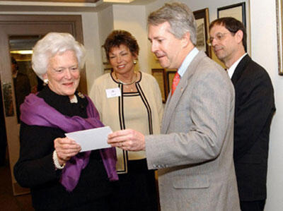 Former first lady Barbara Bush inspects a piece of White House memorabilia with Stephen P. Long, M.D., member of the VCU Health System Authority Board of Directors and the VCU Board of Visitors. Looking on are Babs Jackson, president and CEO, Hospital Hospitality House and Sheldon M. Retchin, M.D. (right), senior executive vice president and chief operating officer of the VCU Health System.