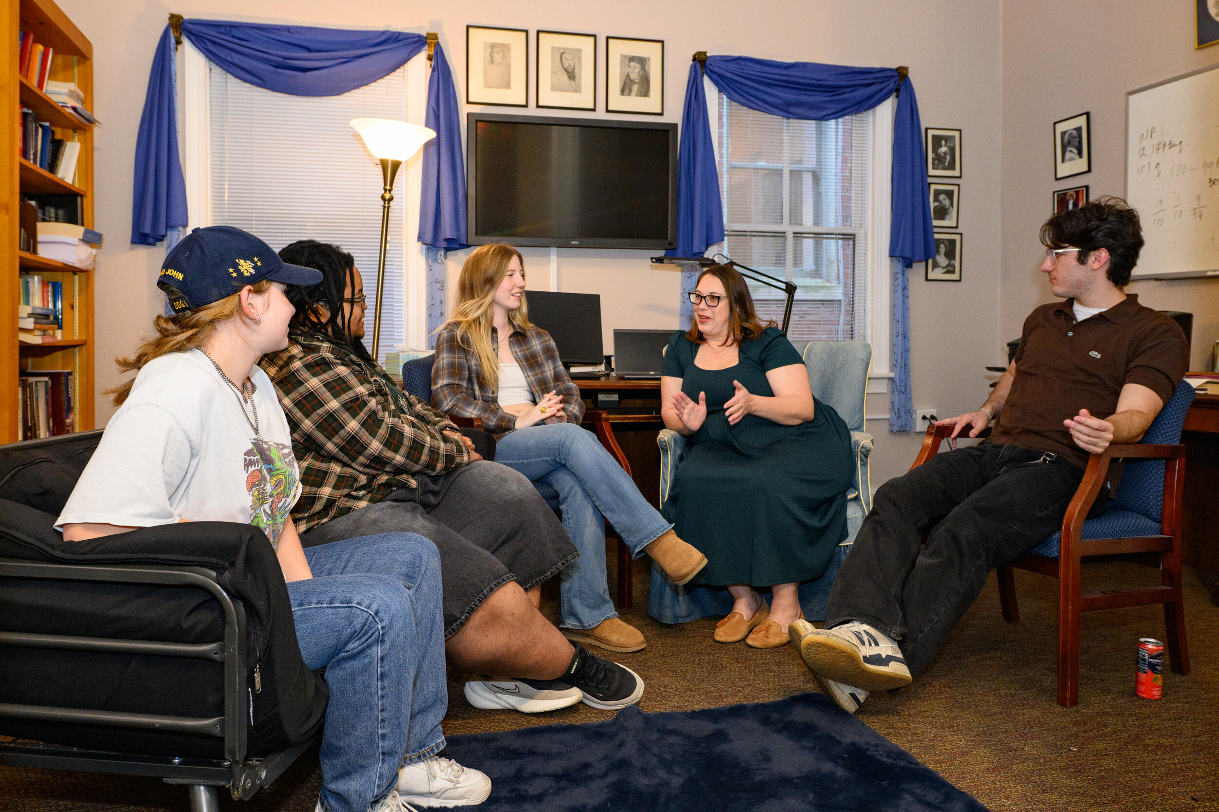 A photo of a group of five people sitting in a semi-circle. 