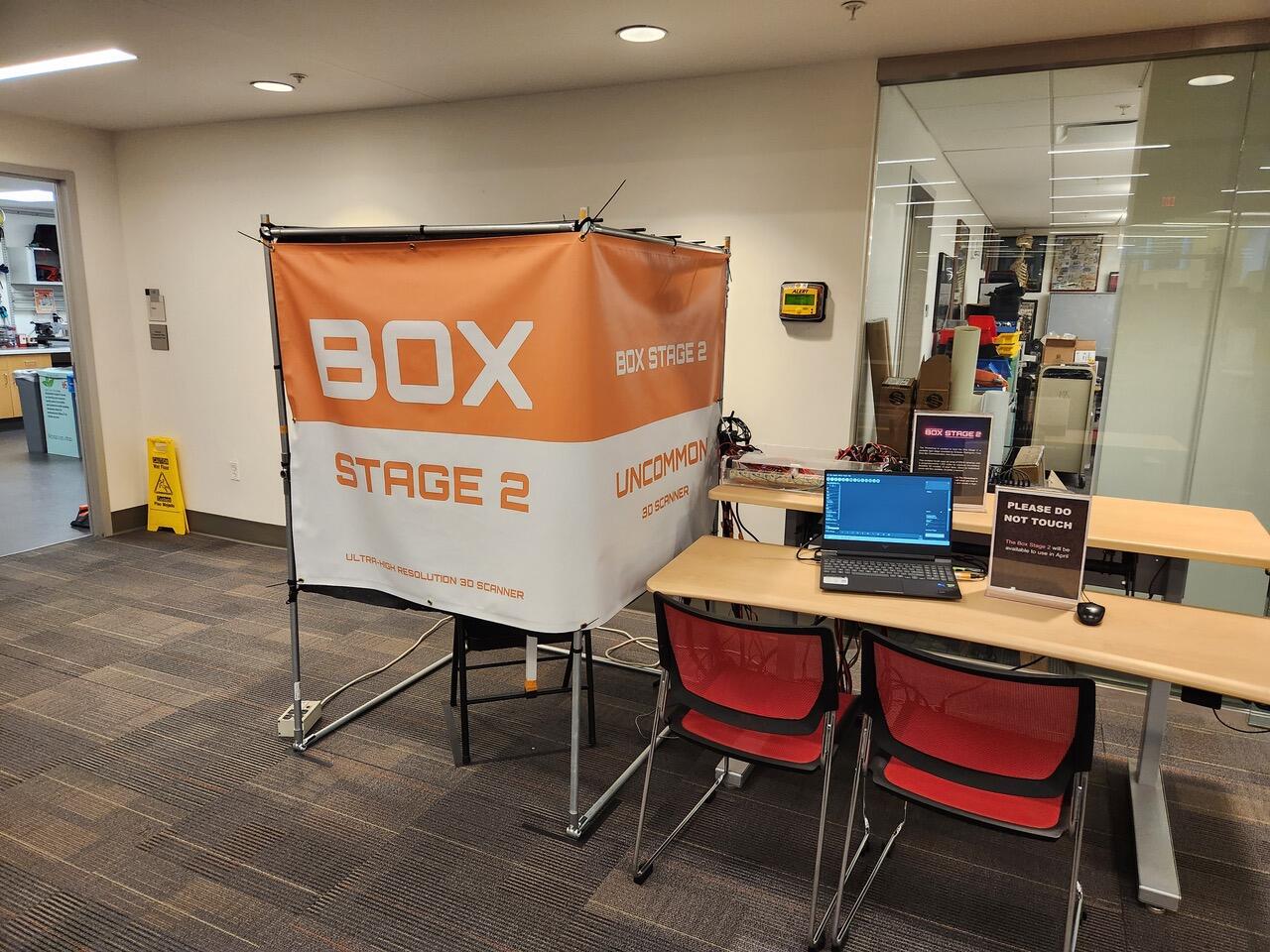 A large white and orange box next to a table with chairs.