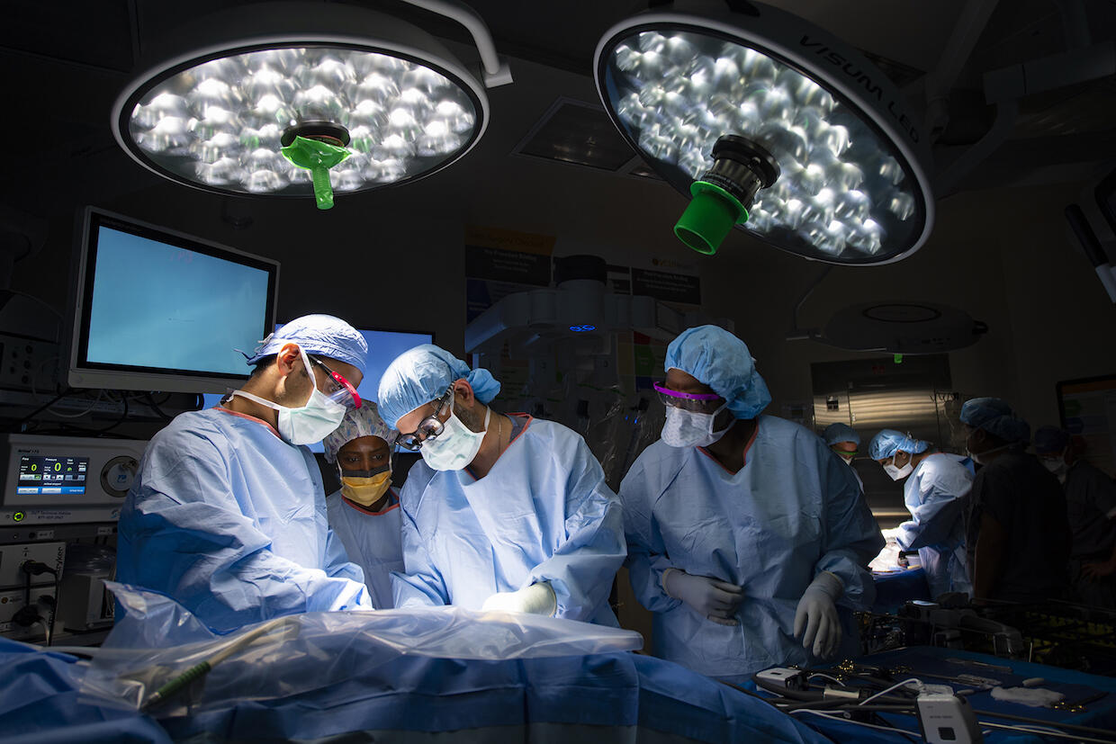 A group of doctors in an operating room performing surgery on a patient.