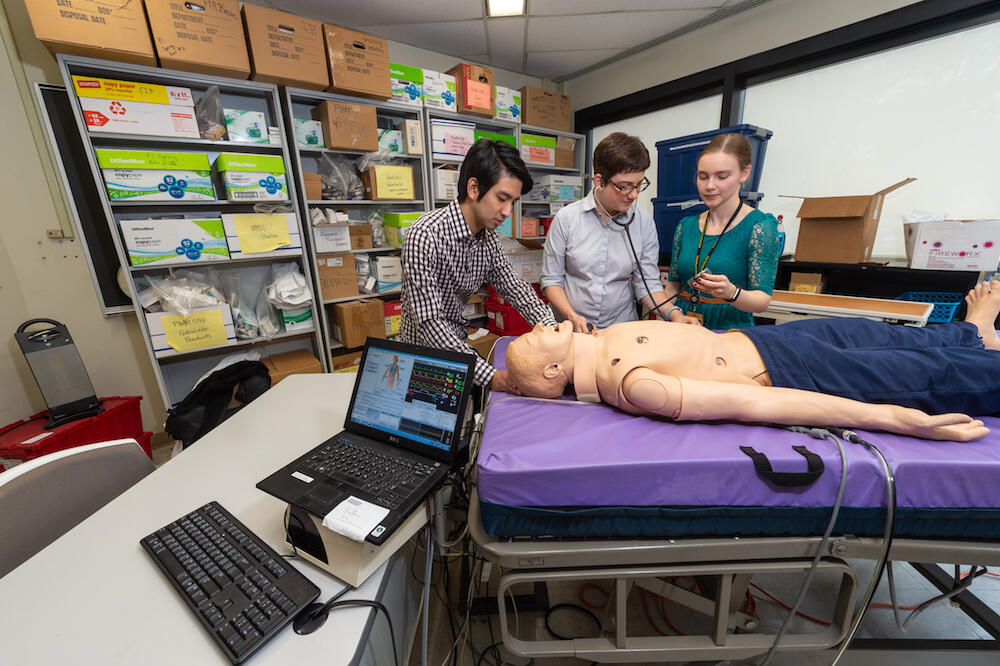 Laura Morgan, Pharm.D., takes readings from SimMan with Allen and classmate David Lee. (Photo by Kevin Morley, University Relations)
