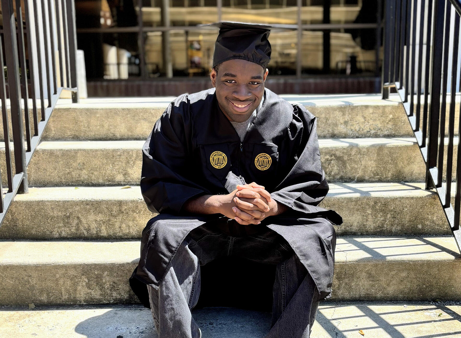 A photo of a man wearing a graduation cap and gown. 
