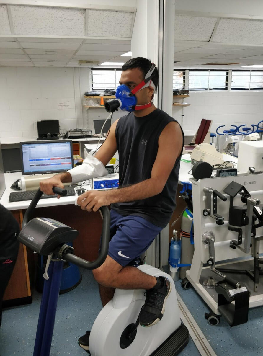 Joshi rides a stationary bike in the lab where he is conducting his Fulbright research in Oxford.